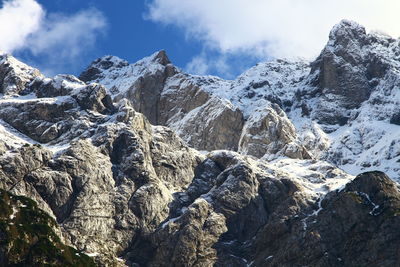 Low angle view of snowcapped mountains against sky