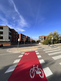 View of road by buildings against sky