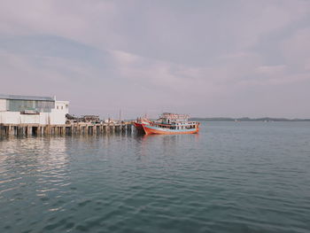 Fishing boat in sea against sky