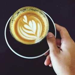 Close-up of hand holding coffee cup