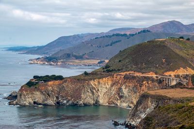Scenic view of sea and mountains against sky