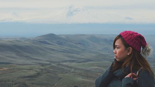 Beautiful woman standing on mountain against sky