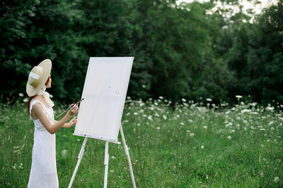 Woman holding umbrella standing on field