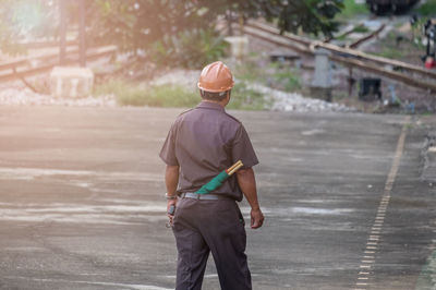 Rear view of man walking at railroad station platform