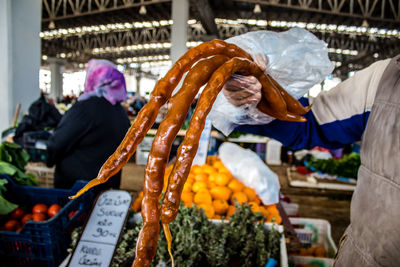 Midsection of man holding fruits at market stall