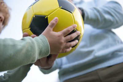 A little boy plays soccer with his father on the soccer field