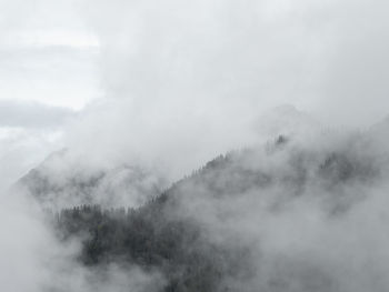 Scenic view of foggy weather against sky