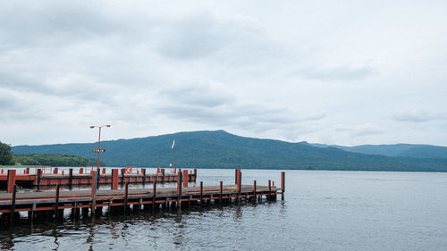 Scenic view of lake and piers against sky