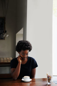 Portrait of young woman sitting at table