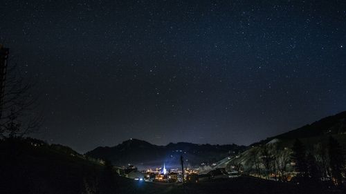 Scenic view of illuminated mountains against sky at night