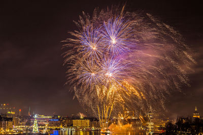 Firework display against sky at night