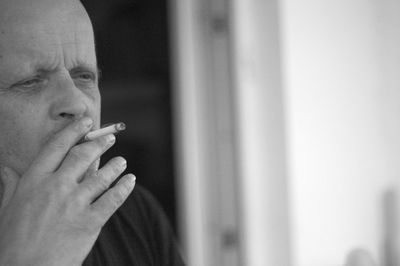 Man looking away while smoking cigarette