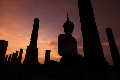 Silhouette statue against sky at sunset