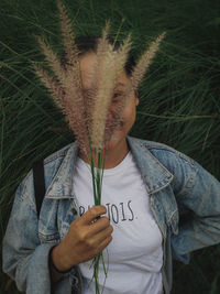 Portrait of woman holding plant