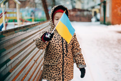 Girl holding ukrainian flag outdoors