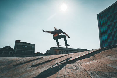 Low angle view of man jumping on built structure