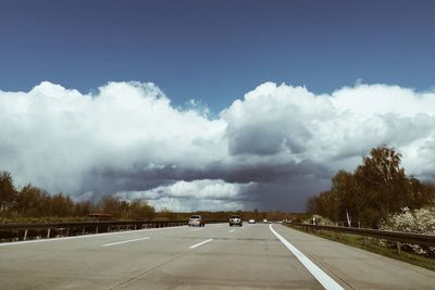 Road amidst trees against sky