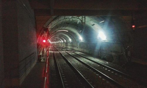 Illuminated railroad tracks at night