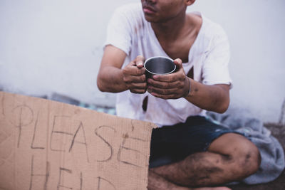 Midsection of man holding coffee cup