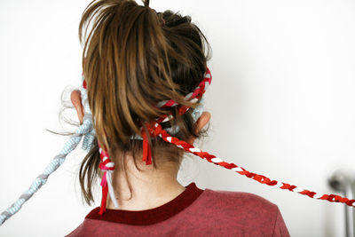 Rear view of woman with red hair against white background