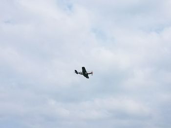 Low angle view of airplane flying against sky