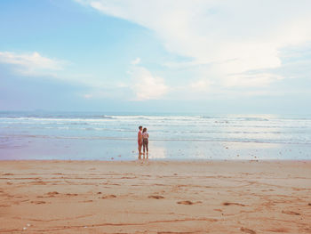 Happy romantic couple enjoying beautiful sunset walk on the beach. pastel colors tone