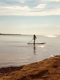 Silhouette person standing on beach against sky