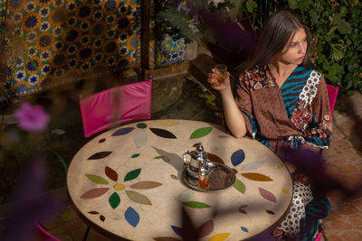 High angle view of girl sitting on table