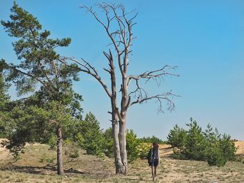 Rear view of woman walking on field