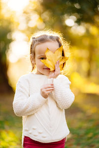 Midsection of woman with umbrella standing on land