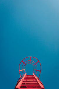 Low angle view of ferris wheel against blue sky