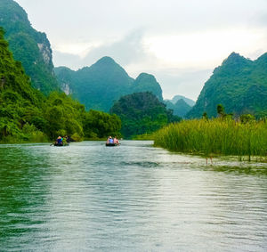 Scenic view of river and mountains against sky