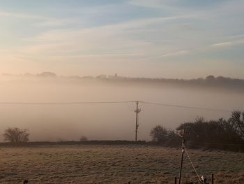 Scenic view of landscape against sky during foggy weather
