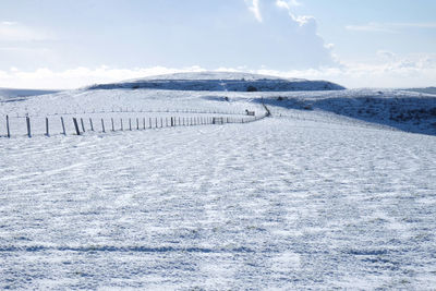 Scenic view of snow covered field against sky