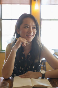 Portrait of a smiling young woman sitting on table