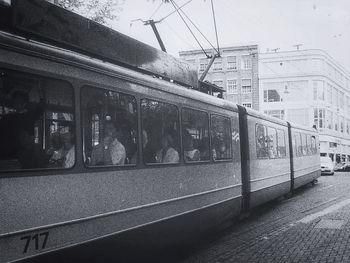 Train on railroad track in city against sky