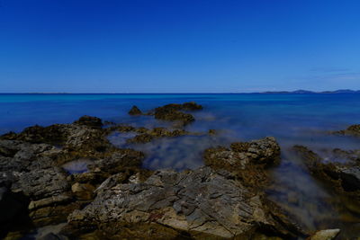 Scenic view of sea against clear blue sky