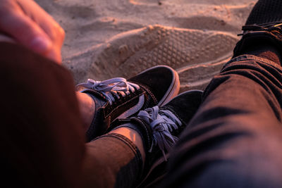 Low section of person sitting on land