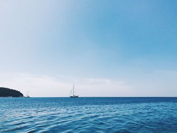 Sailboat sailing in sea against sky