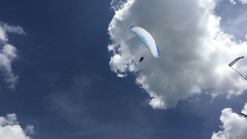 Low angle view of paragliding against sky