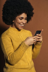 Smiling young woman using mobile phone