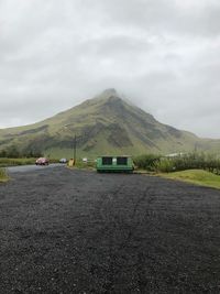 Road by mountain against sky