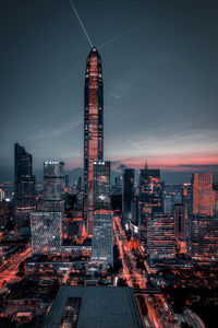 Illuminated buildings in city against sky at night