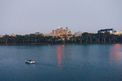 Boats sailing in river against clear sky