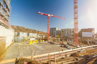 Cranes at construction site against sky in city