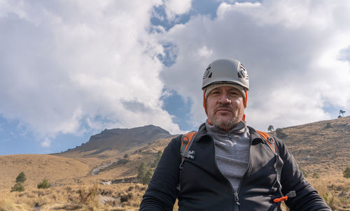 Portrait of man standing against mountain