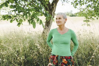 Portrait of young woman standing against plants