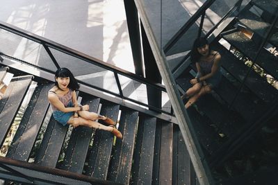 High angle portrait of mid adult woman sitting on steps