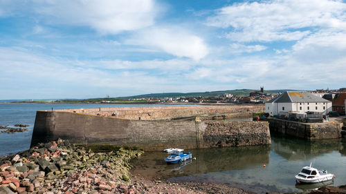 Scenic view of beach by buildings against sky