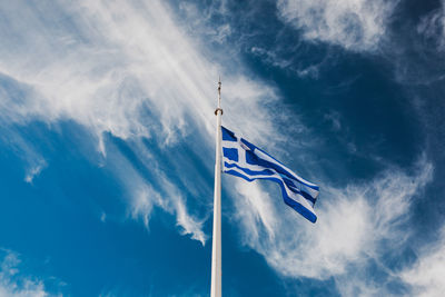 Low angle view of flag against blue sky